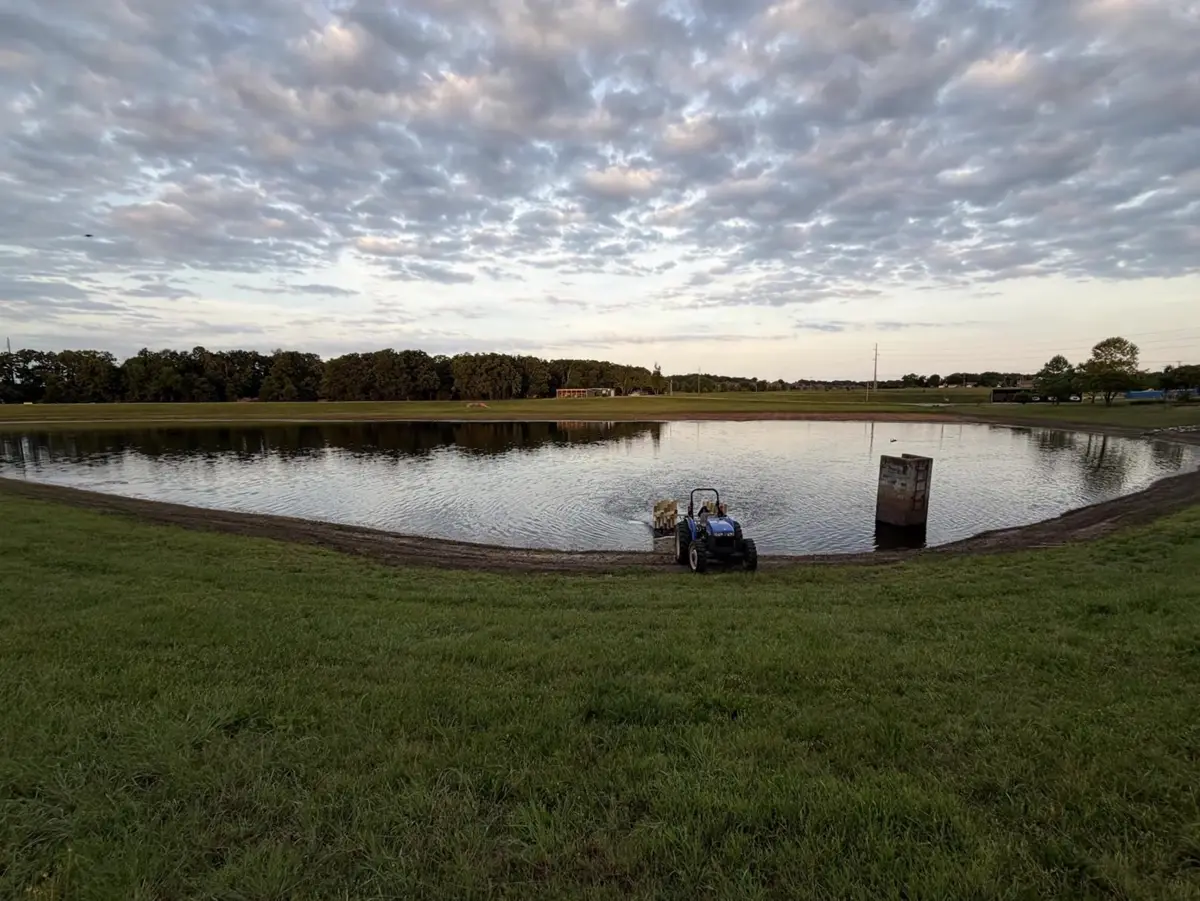 Open field and a hatchery pond at dusk in Centerton, Arkansas, the kind of land slated for the city's planned new downtown