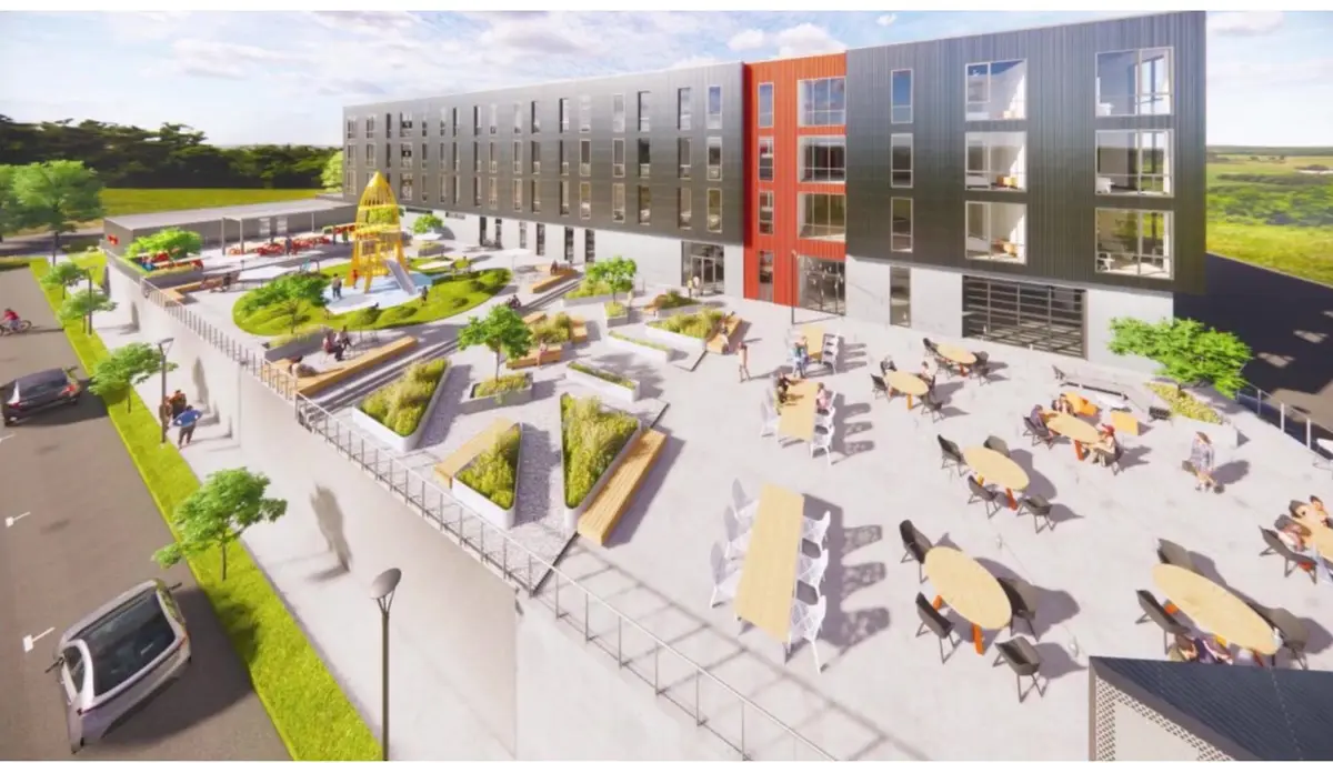 Rendering of a four-story apartment building with a large outdoor courtyard, playground and communal tables in Fayetteville, Arkansas