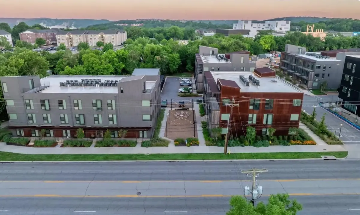 Aerial view at dusk of new three-storey infill apartment buildings along a Northwest Arkansas corridor