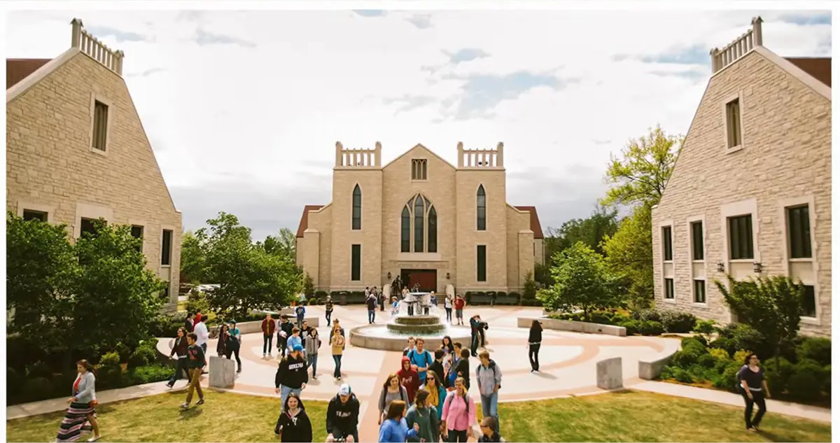 Students crossing the fountain plaza at John Brown University in Siloam Springs, Arkansas, with the campus chapel behind