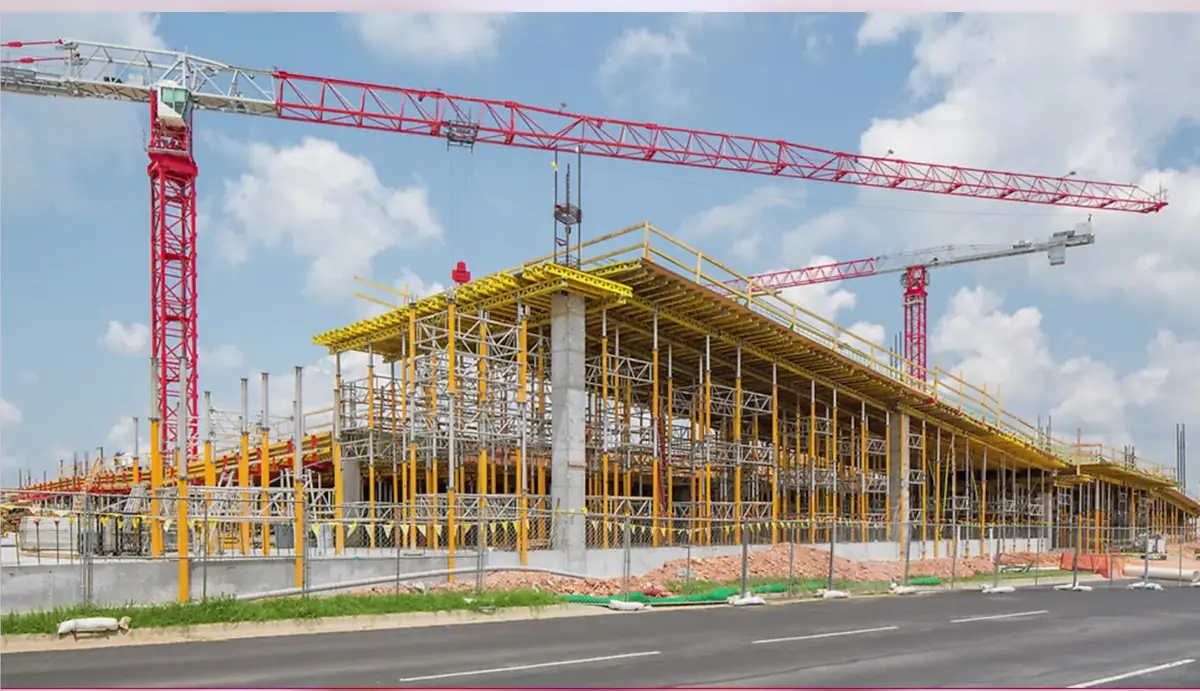 Tower cranes above a large commercial building under construction in Northwest Arkansas