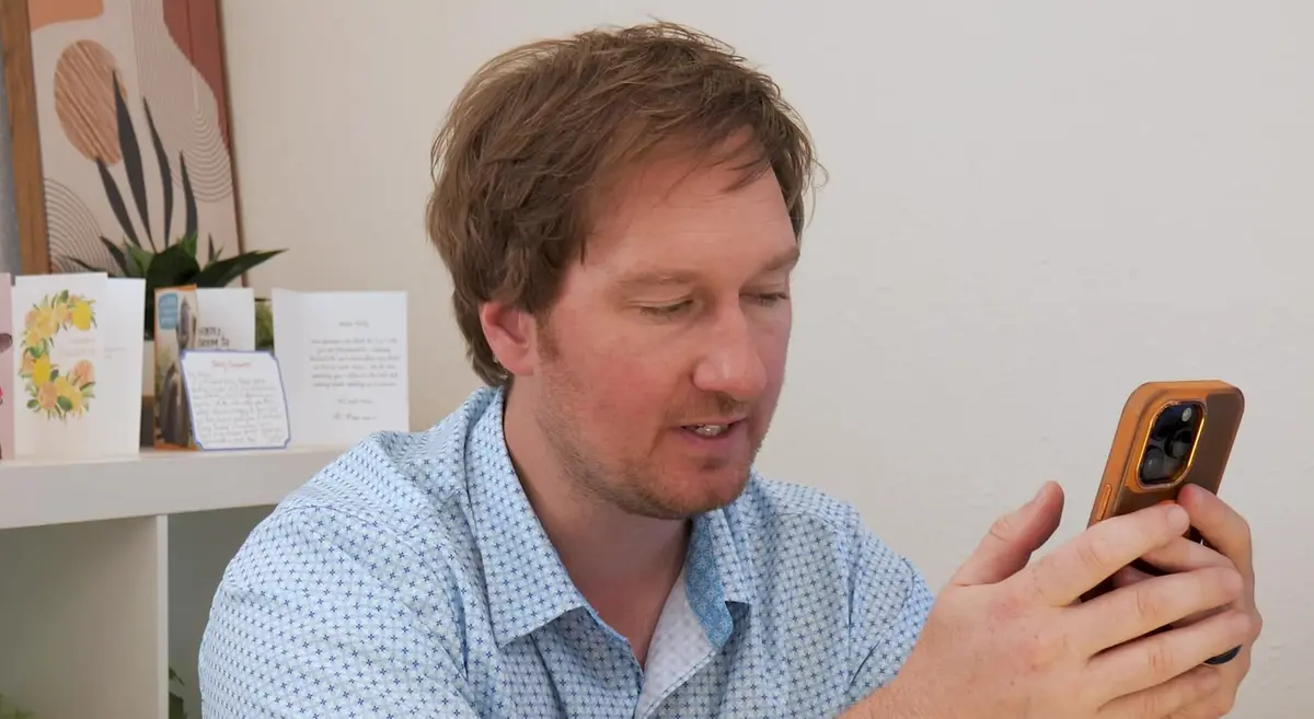 Phillip Shepard, a Northwest Arkansas real estate agent, watching TikTok videos about the region on his phone
